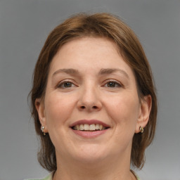 Joyful white adult female with medium  brown hair and grey eyes