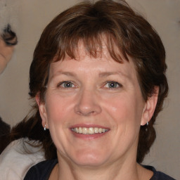 Joyful white adult female with medium  brown hair and blue eyes