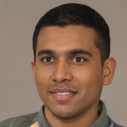 Joyful black young-adult male with short  black hair and brown eyes