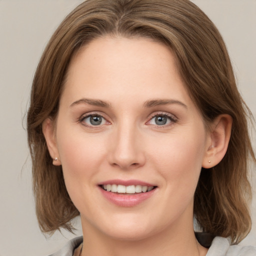 Joyful white young-adult female with medium  brown hair and green eyes