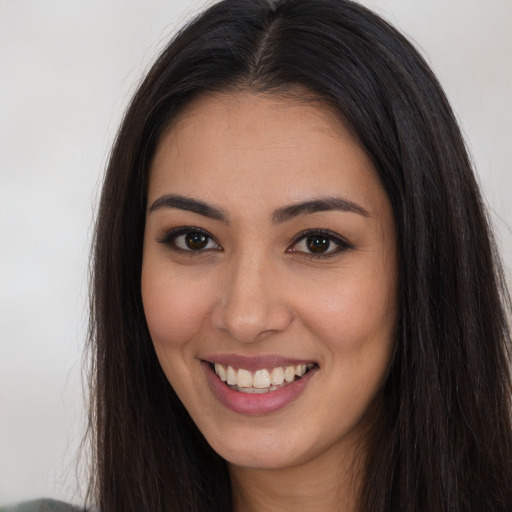 Joyful latino young-adult female with long  brown hair and brown eyes