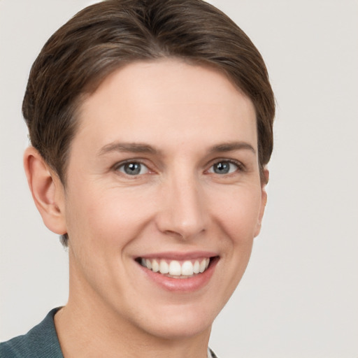 Joyful white young-adult female with short  brown hair and grey eyes