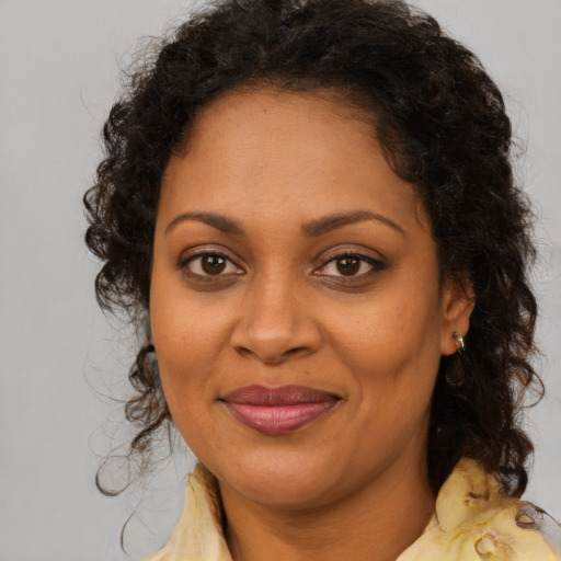 Joyful black adult female with medium  brown hair and brown eyes