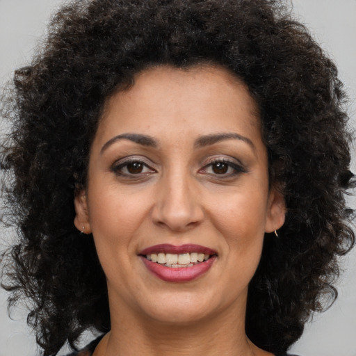 Joyful latino young-adult female with long  brown hair and brown eyes