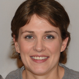 Joyful white adult female with medium  brown hair and blue eyes