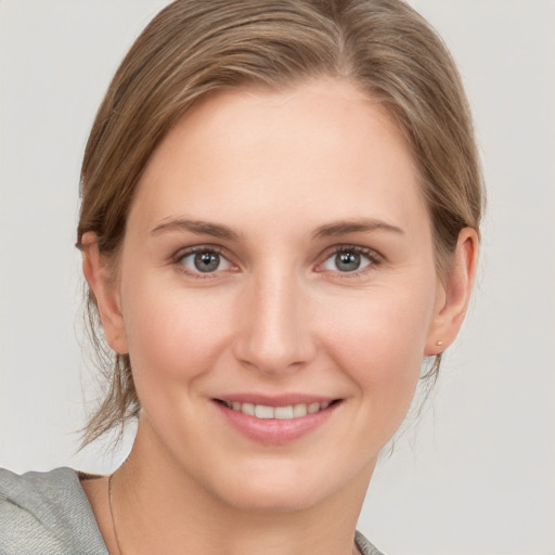 Joyful white young-adult female with medium  brown hair and grey eyes