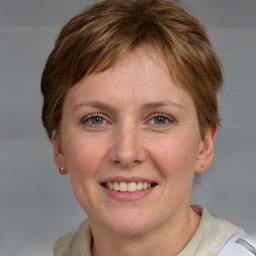 Joyful white adult female with medium  brown hair and grey eyes