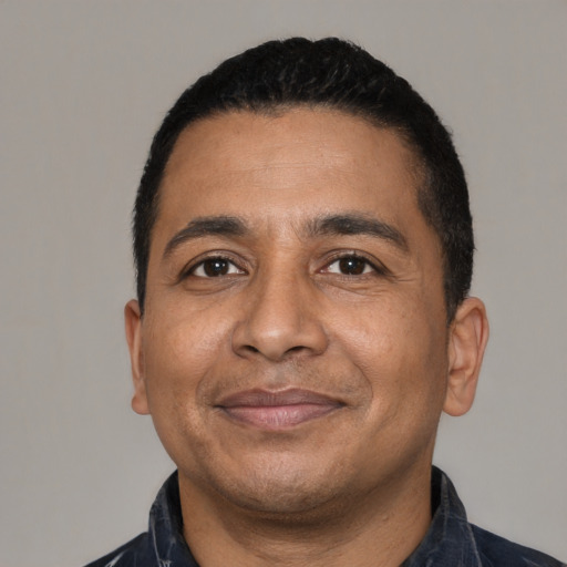 Joyful latino adult male with short  black hair and brown eyes