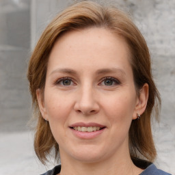 Joyful white young-adult female with medium  brown hair and blue eyes