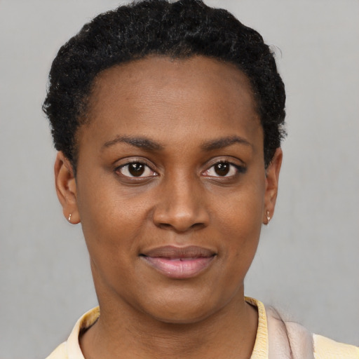 Joyful black young-adult female with short  black hair and brown eyes