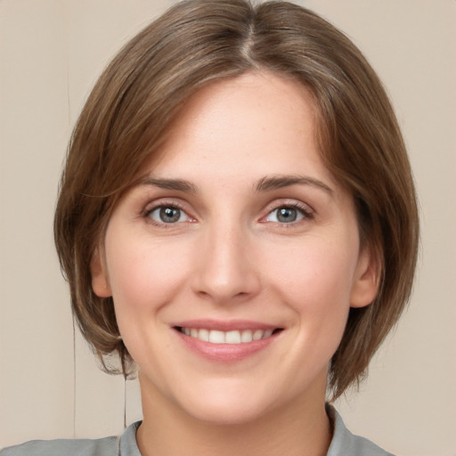 Joyful white young-adult female with medium  brown hair and grey eyes