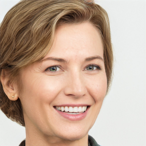 Joyful white adult female with medium  brown hair and green eyes