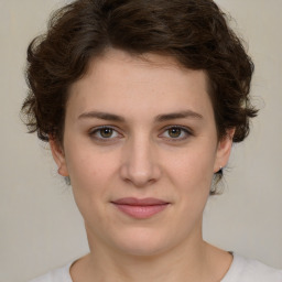 Joyful white young-adult female with medium  brown hair and green eyes