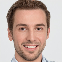 Joyful white young-adult male with short  brown hair and grey eyes