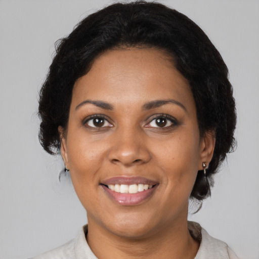 Joyful black adult female with medium  black hair and brown eyes