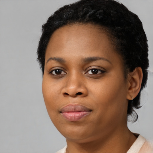 Joyful black young-adult female with short  black hair and brown eyes