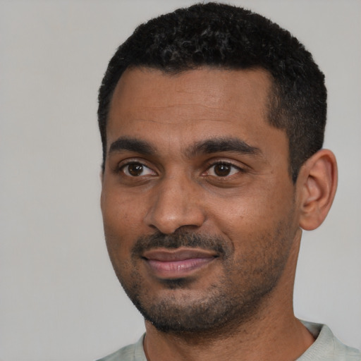 Joyful black young-adult male with short  black hair and brown eyes