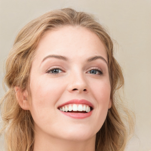 Joyful white young-adult female with long  brown hair and blue eyes