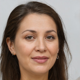 Joyful white adult female with long  brown hair and brown eyes