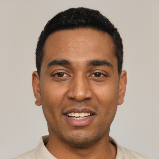 Joyful black young-adult male with short  black hair and brown eyes