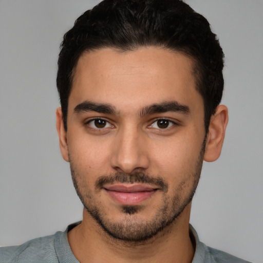 Joyful latino young-adult male with short  black hair and brown eyes