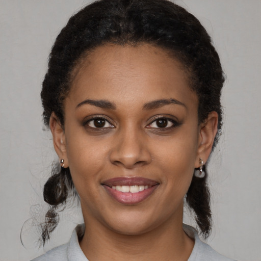 Joyful black young-adult female with medium  brown hair and brown eyes