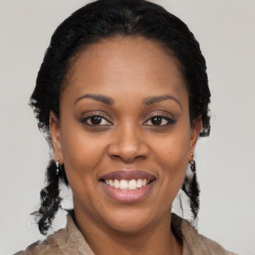 Joyful black young-adult female with long  black hair and brown eyes