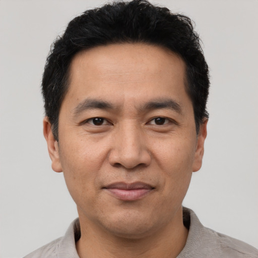 Joyful asian adult male with short  brown hair and brown eyes