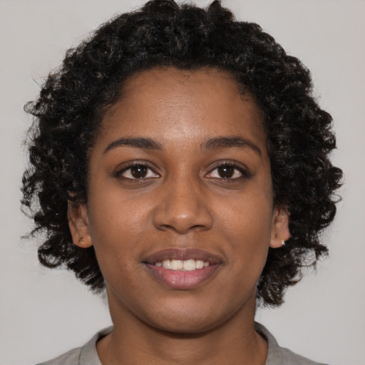 Joyful black young-adult female with short  brown hair and brown eyes