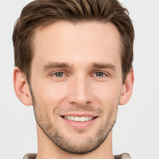 Joyful white young-adult male with short  brown hair and grey eyes