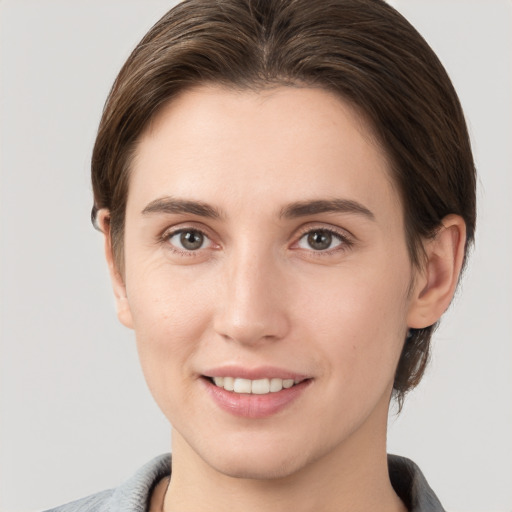 Joyful white young-adult female with medium  brown hair and grey eyes