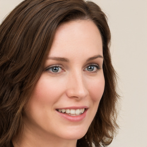 Joyful white young-adult female with long  brown hair and green eyes