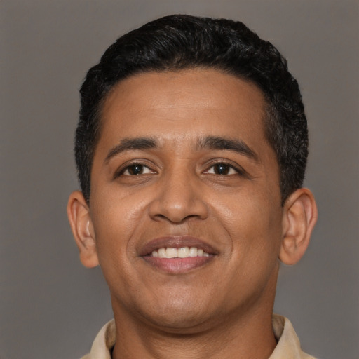 Joyful latino young-adult male with short  black hair and brown eyes