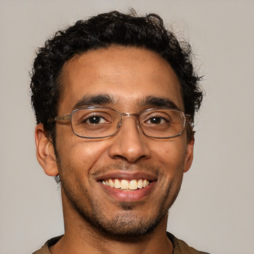 Joyful latino young-adult male with short  brown hair and brown eyes