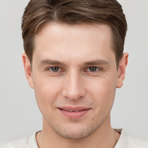 Joyful white young-adult male with short  brown hair and grey eyes