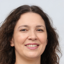 Joyful white adult female with long  brown hair and brown eyes