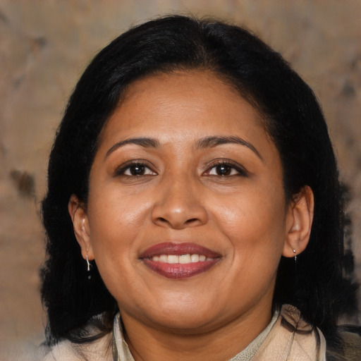 Joyful latino adult female with medium  brown hair and brown eyes