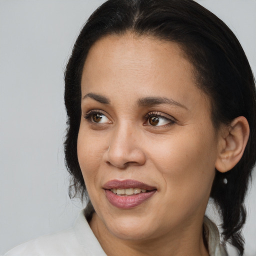 Joyful black young-adult female with long  brown hair and brown eyes