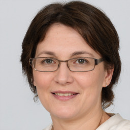 Joyful white adult female with medium  brown hair and brown eyes