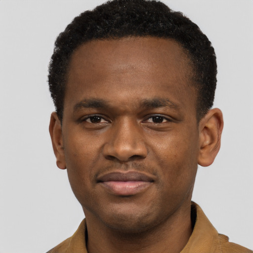 Joyful black young-adult male with short  brown hair and brown eyes