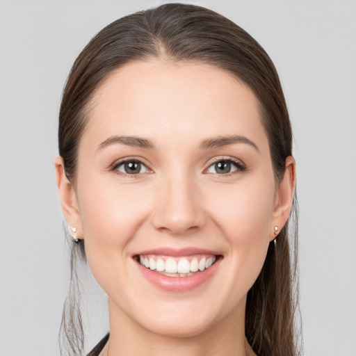 Joyful white young-adult female with long  brown hair and brown eyes