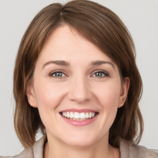 Joyful white young-adult female with medium  brown hair and grey eyes