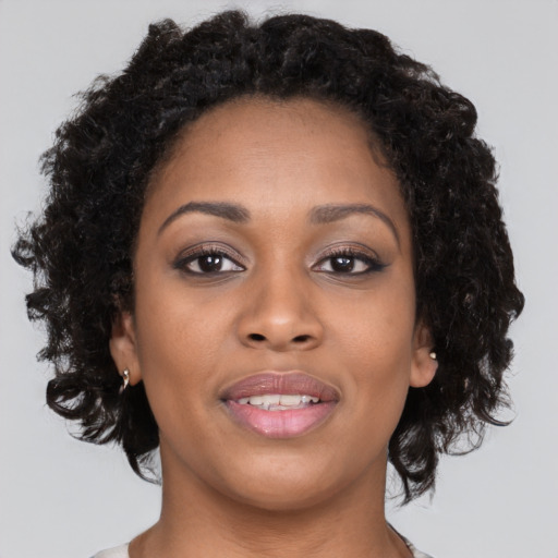 Joyful black young-adult female with long  brown hair and brown eyes