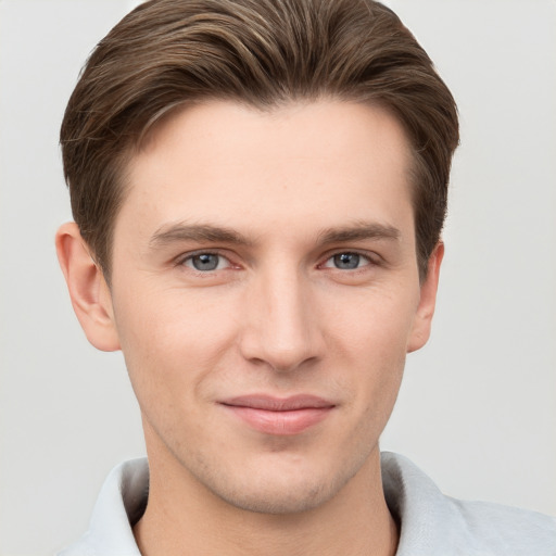 Joyful white young-adult male with short  brown hair and grey eyes