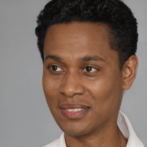 Joyful black young-adult male with short  black hair and brown eyes