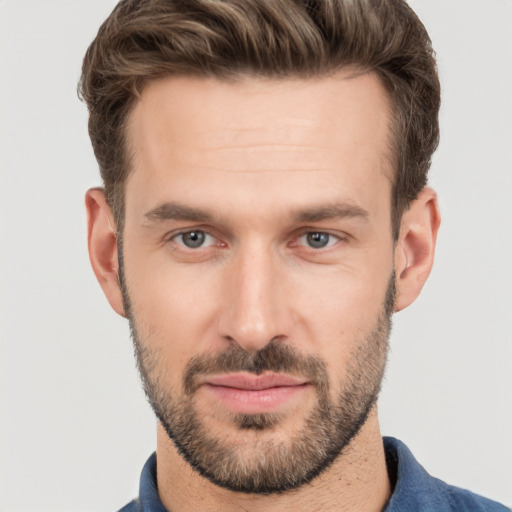 Joyful white young-adult male with short  brown hair and grey eyes