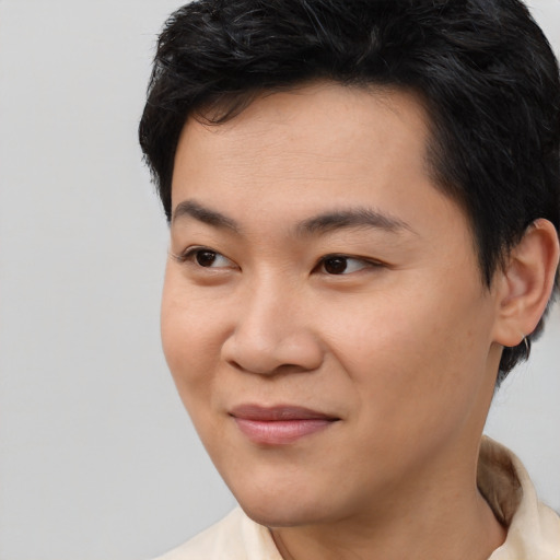 Joyful asian young-adult male with short  black hair and brown eyes