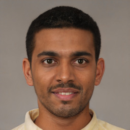 Joyful black young-adult male with short  brown hair and brown eyes