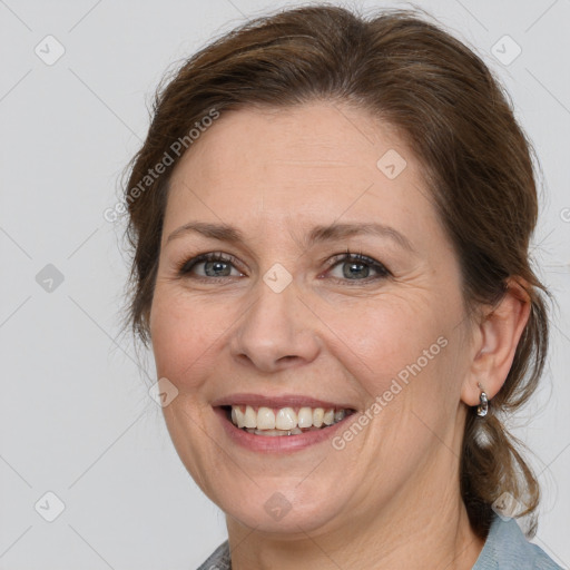 Joyful white adult female with medium  brown hair and grey eyes