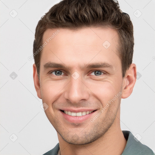 Joyful white young-adult male with short  brown hair and grey eyes